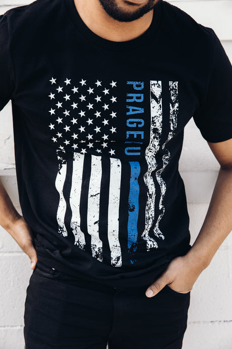 Thin Blue Line distressed flag T-shirt by PragerU featuring a patriotic design and bold blue line on a black shirt.